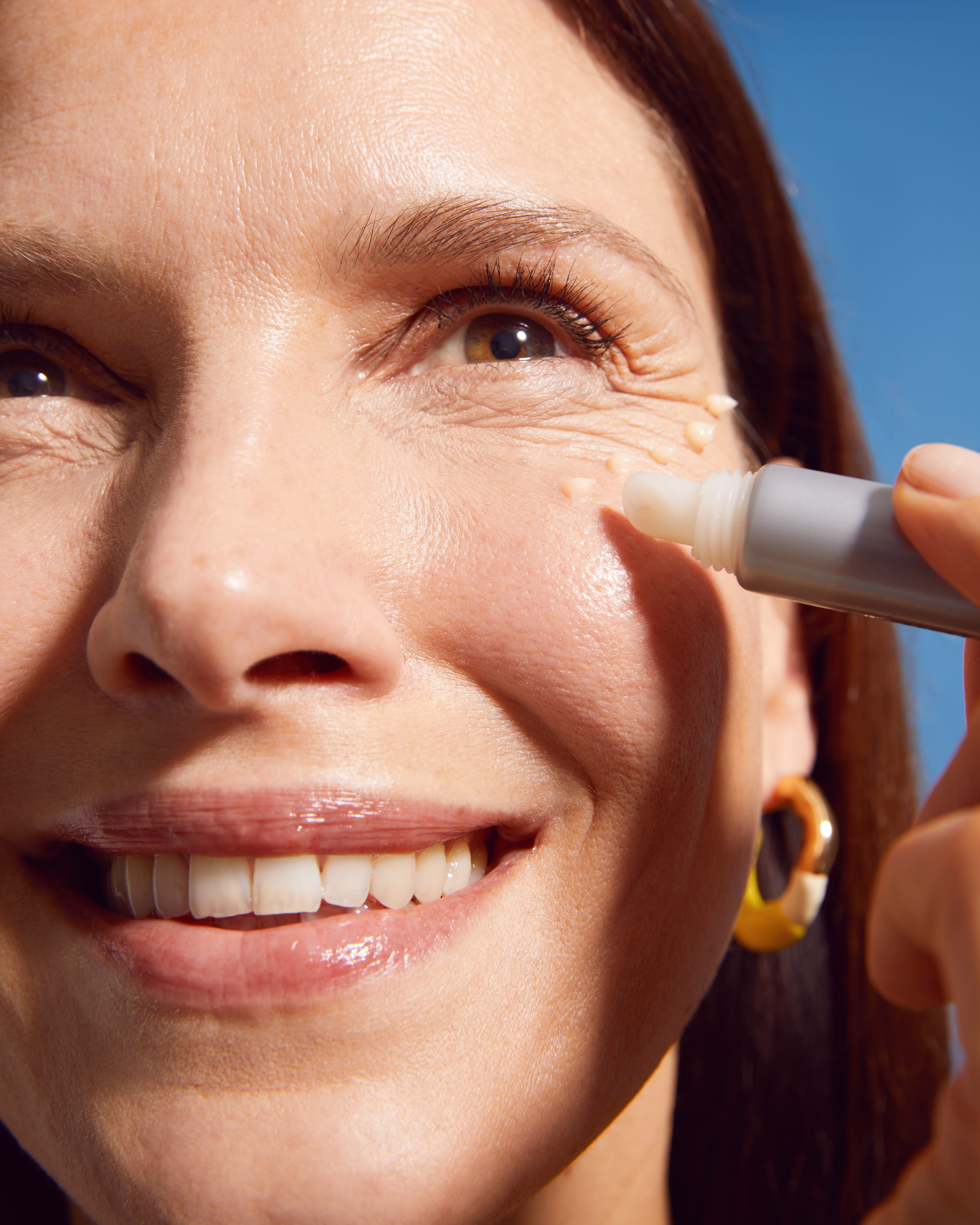 kvinna som håller applicerar Nivea Q10 Expert Wrinkle Filler Serum