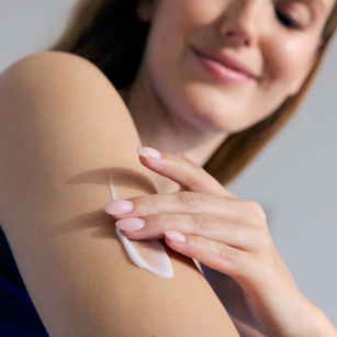 woman applying Nivea body lotion