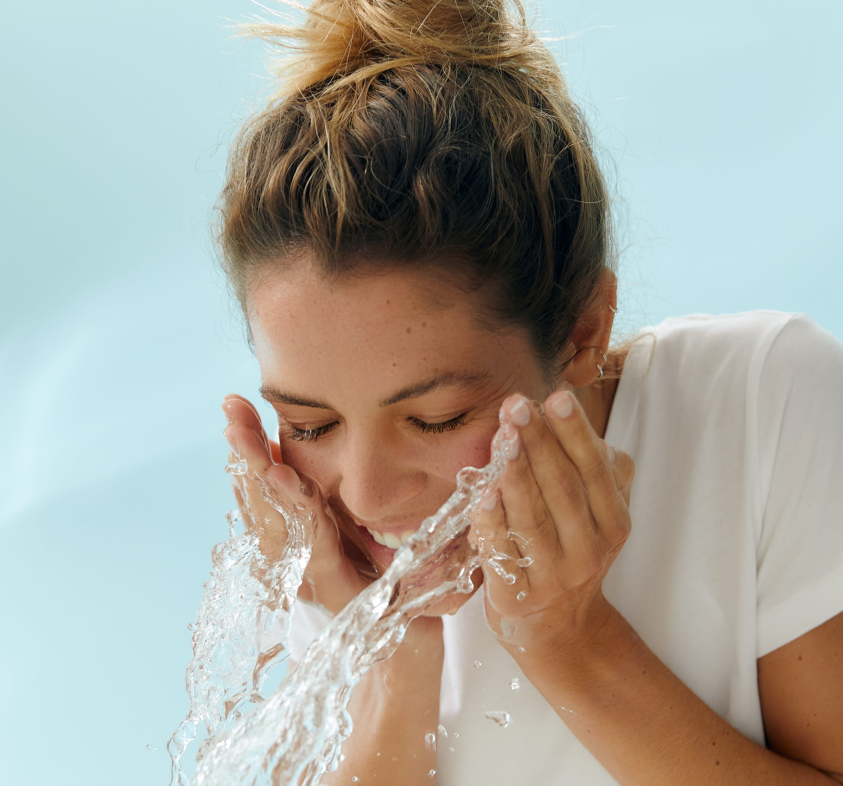 person rengör ansiktet med vatten