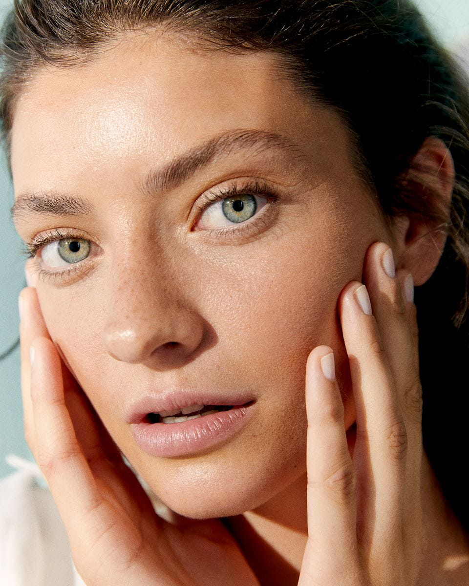 young woman touching her face