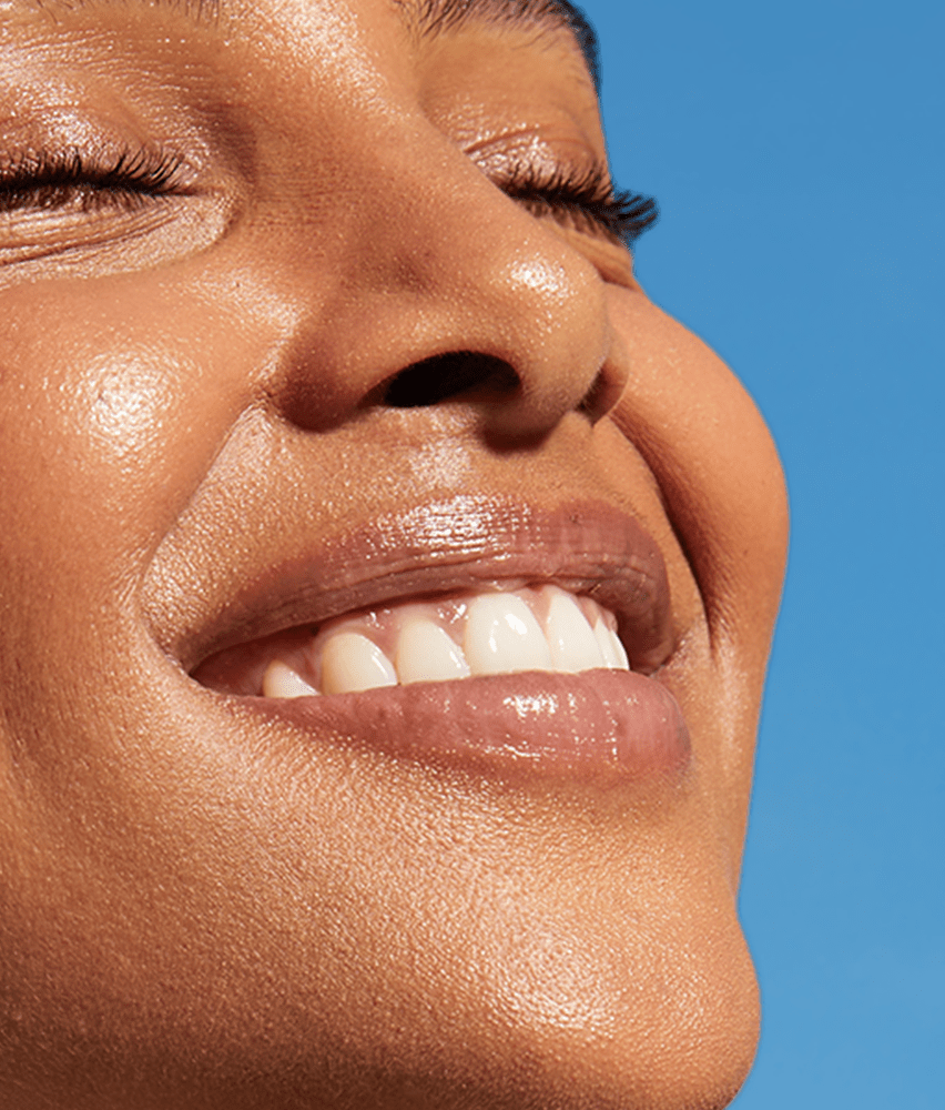 Donna dai capelli rossi con in mano una crema per il viso Nivea Q10