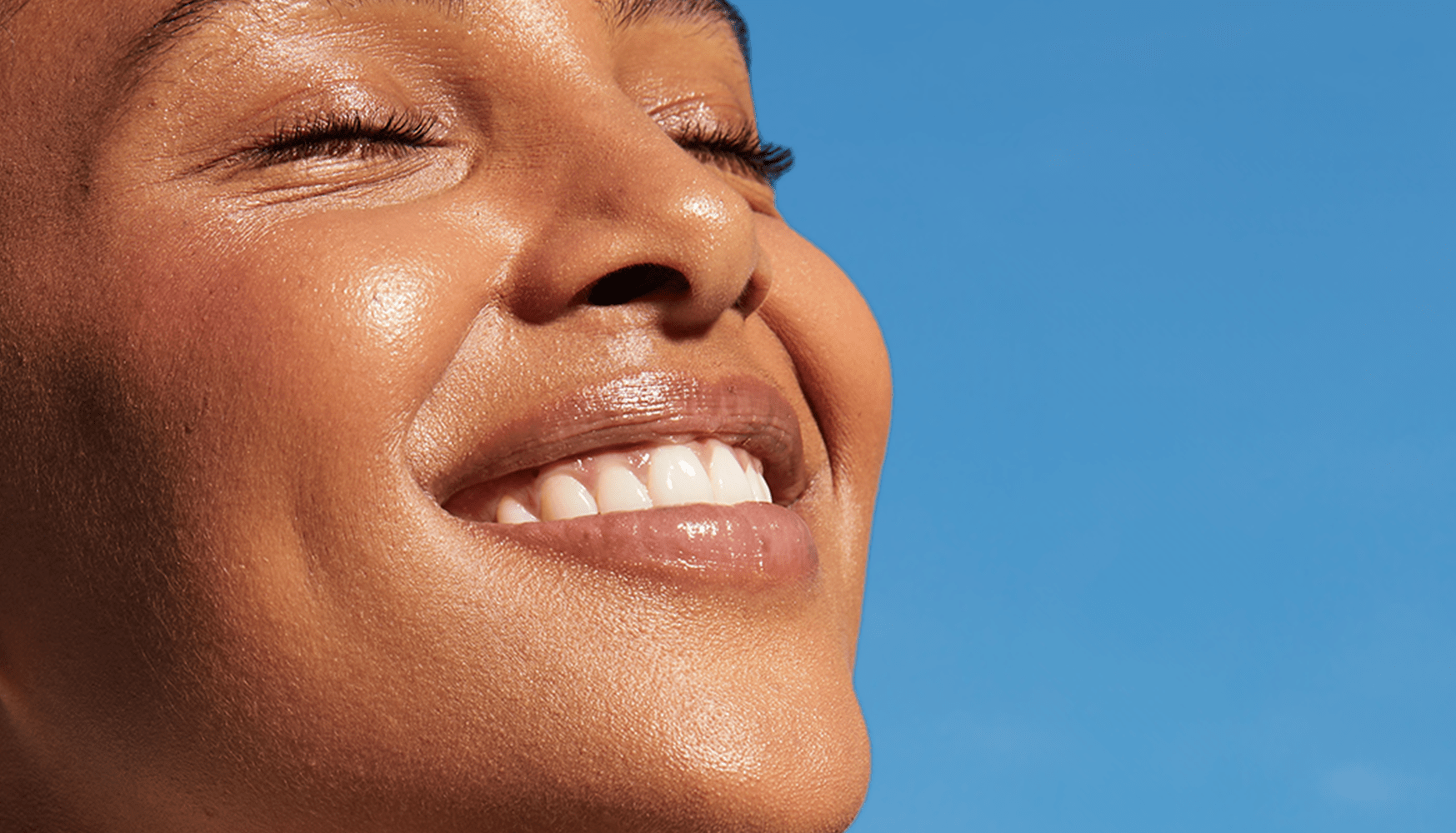 Donna dai capelli rossi con in mano una crema per il viso Nivea Q10