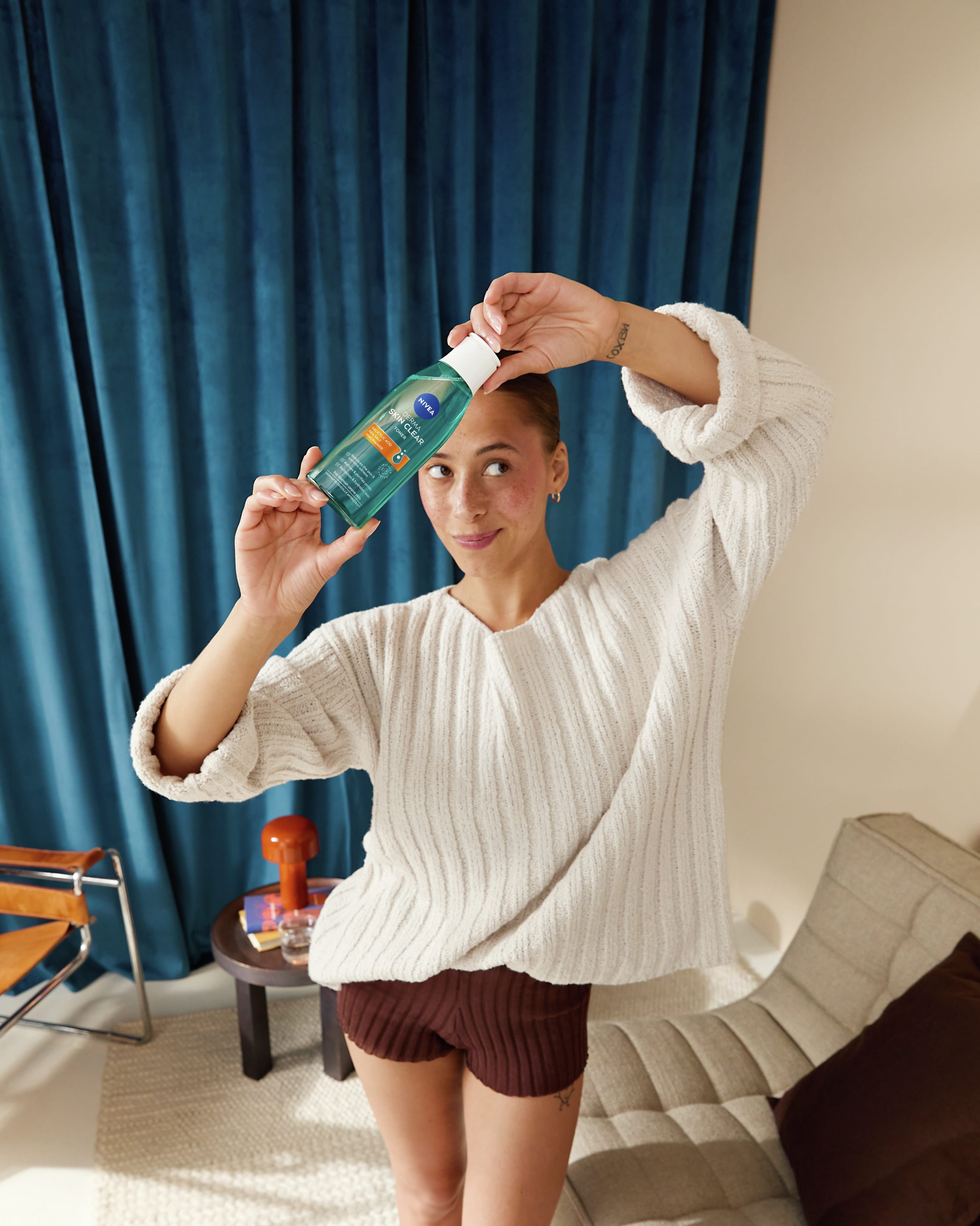 kvinna som håller upp NIVEA Derma Skin Clear toner