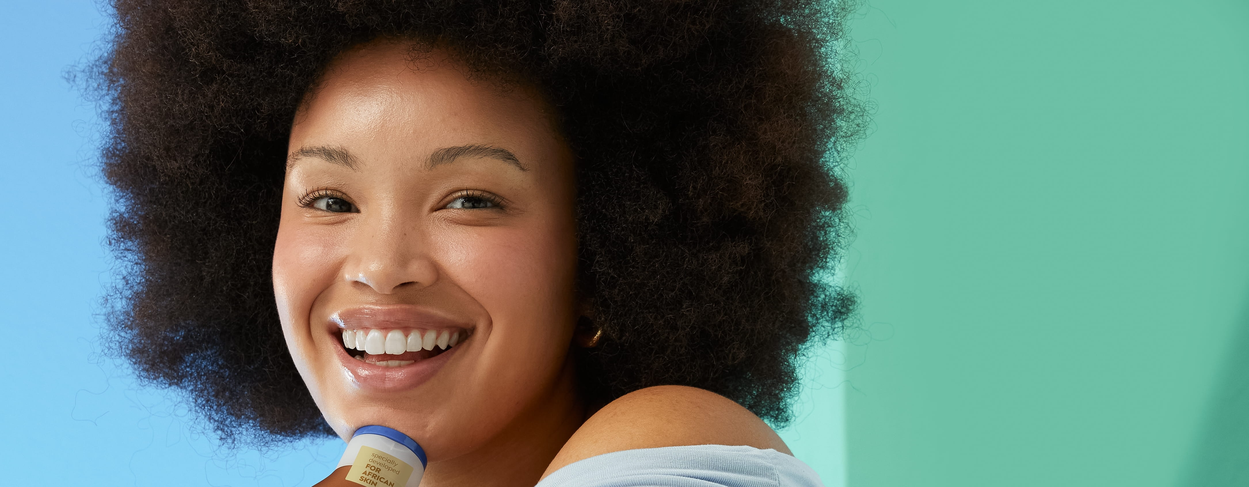 Afro hair young woman using Nivea Radiant and Beauty Body Lotion