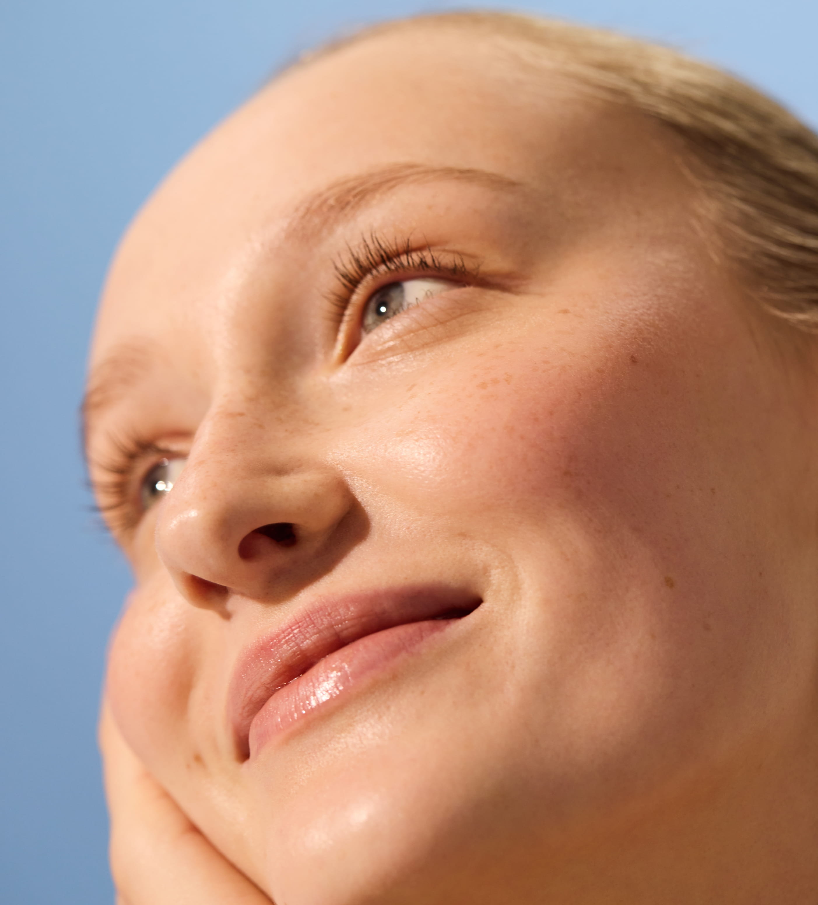 göndör hajú nő Nivea arckrémet alkalmazva