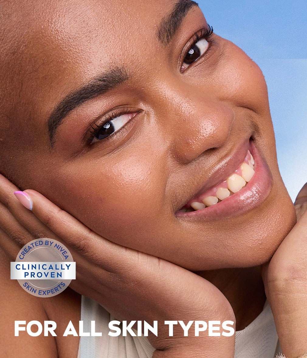 Young woman tilts head to side, cradled by both her hands, framing her glowing skin, with text, "for all skin types".