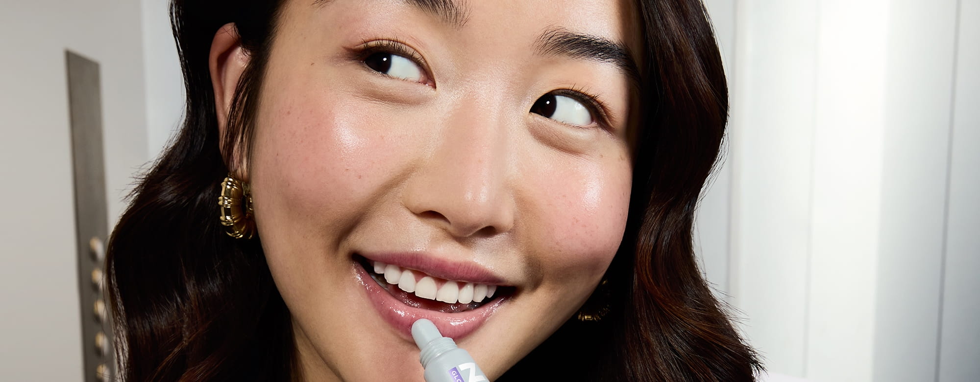 Młoda kobieta używająca Nivea Glowy Lips