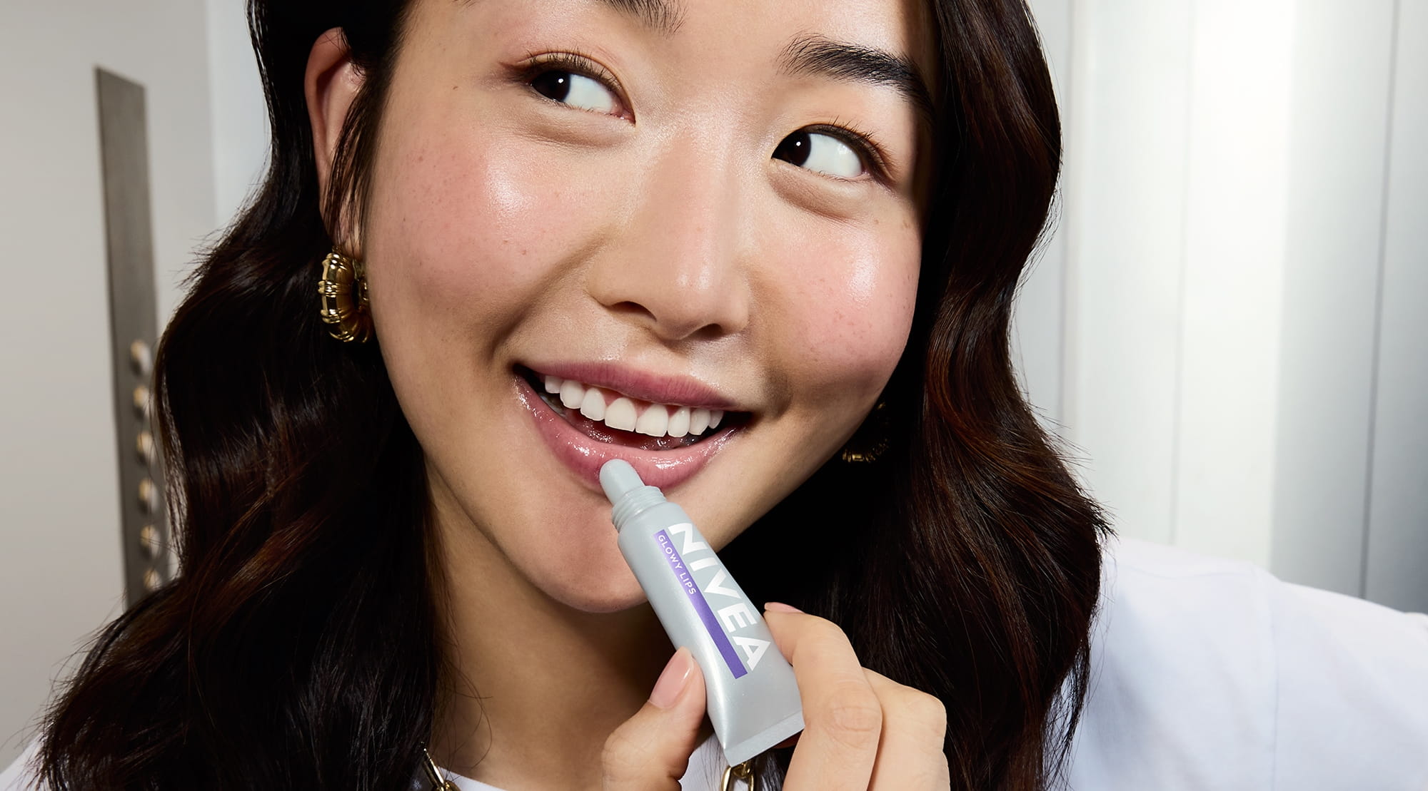 Jeune femme utilisant Nivea Glowy Lips