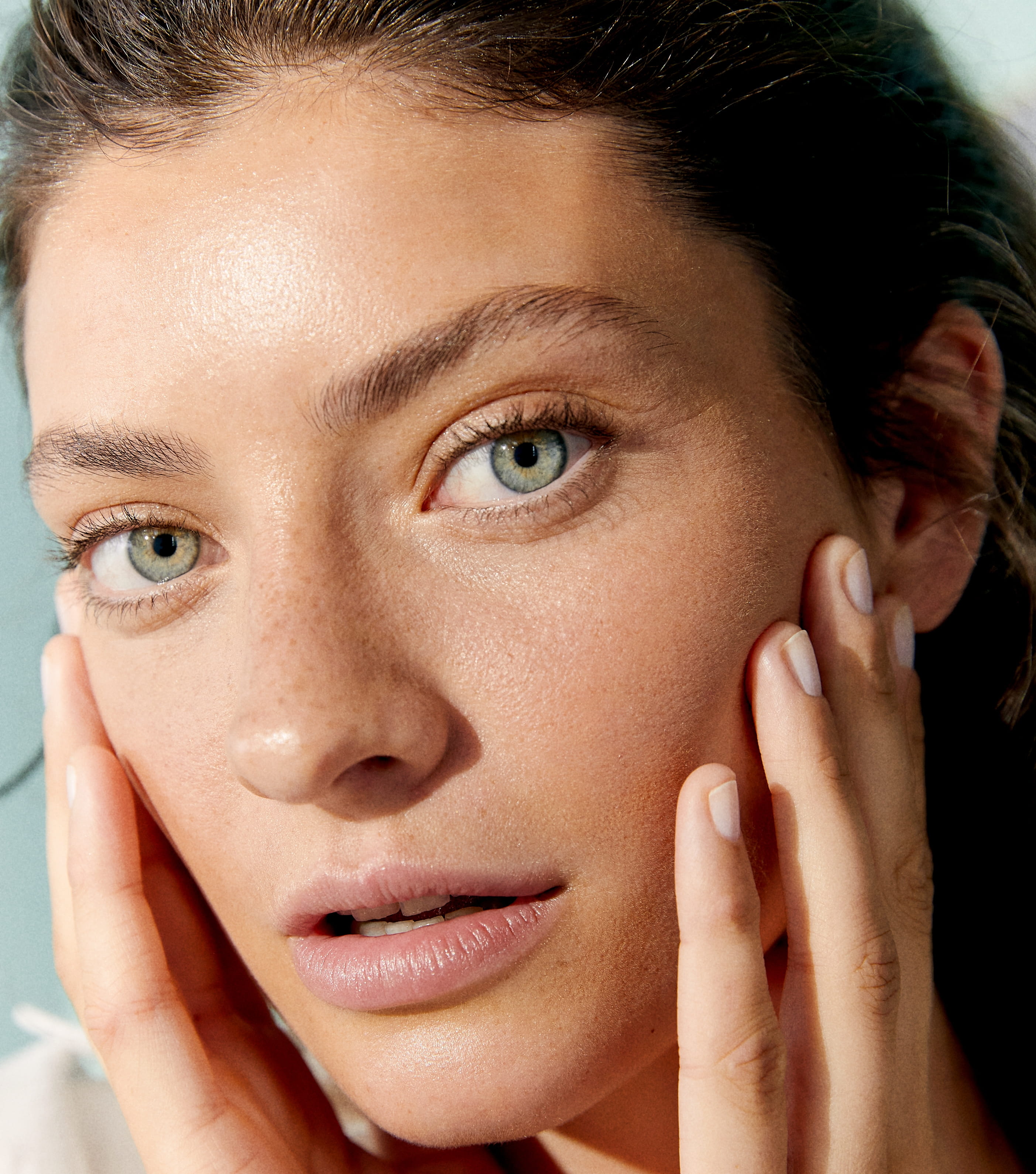 Frau, die sanft Gesichtscreme aufträgt