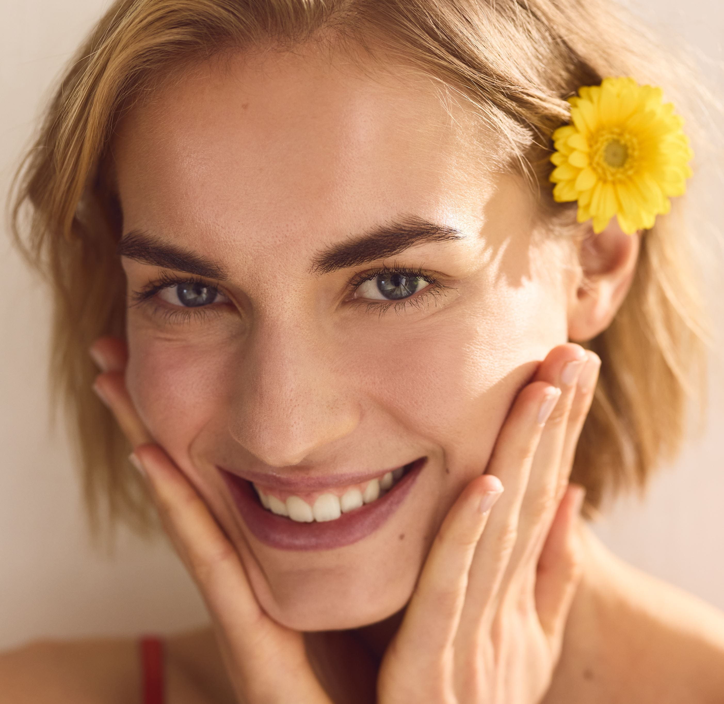 Nasmejana ženska s cvetjem v laseh