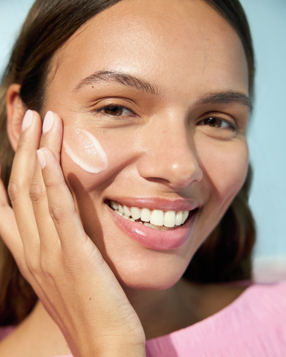 Junge Frau, die Nivea-Gesichtscreme aufträgt