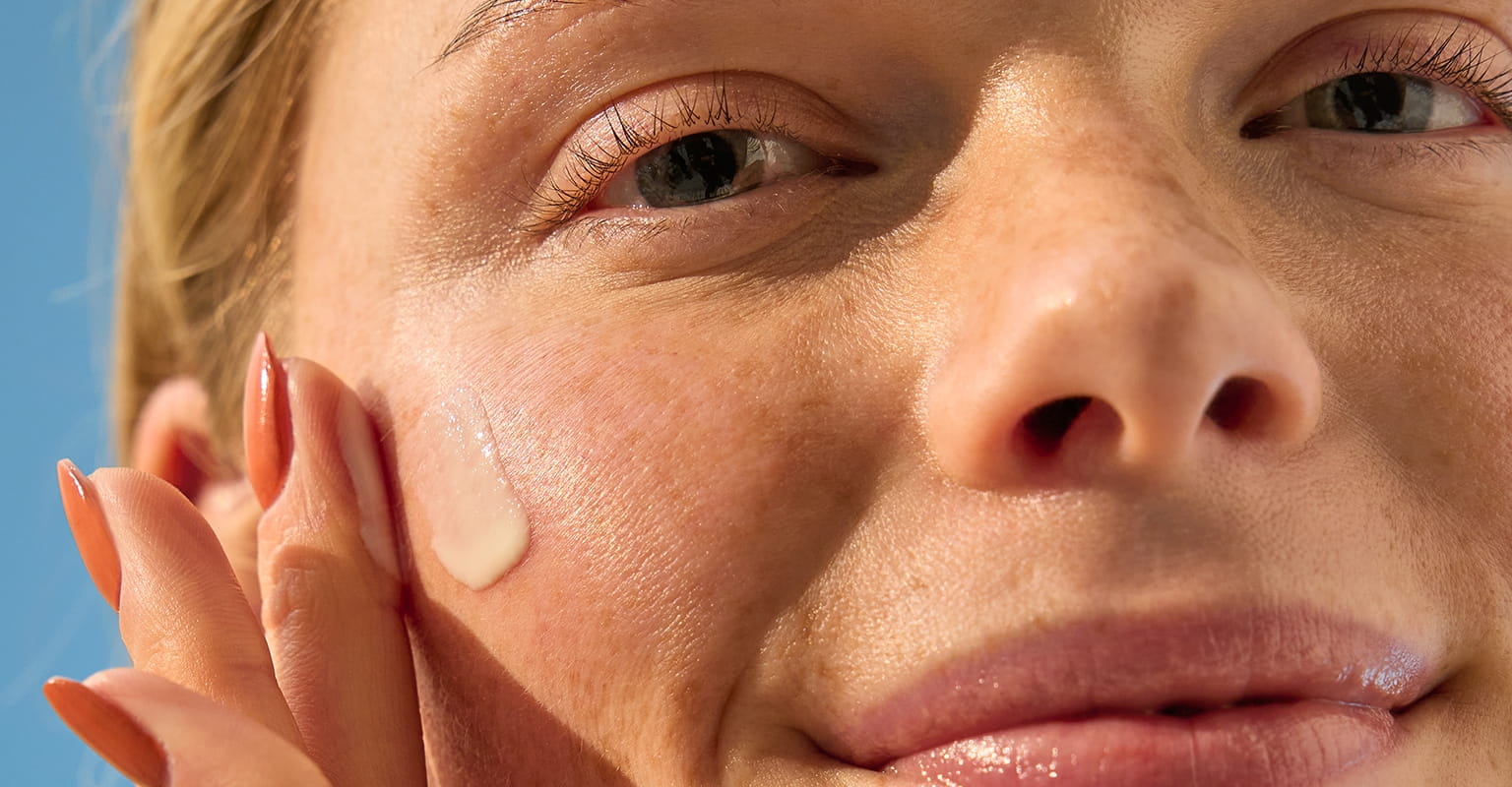 kvinde, der bruger øjencreme