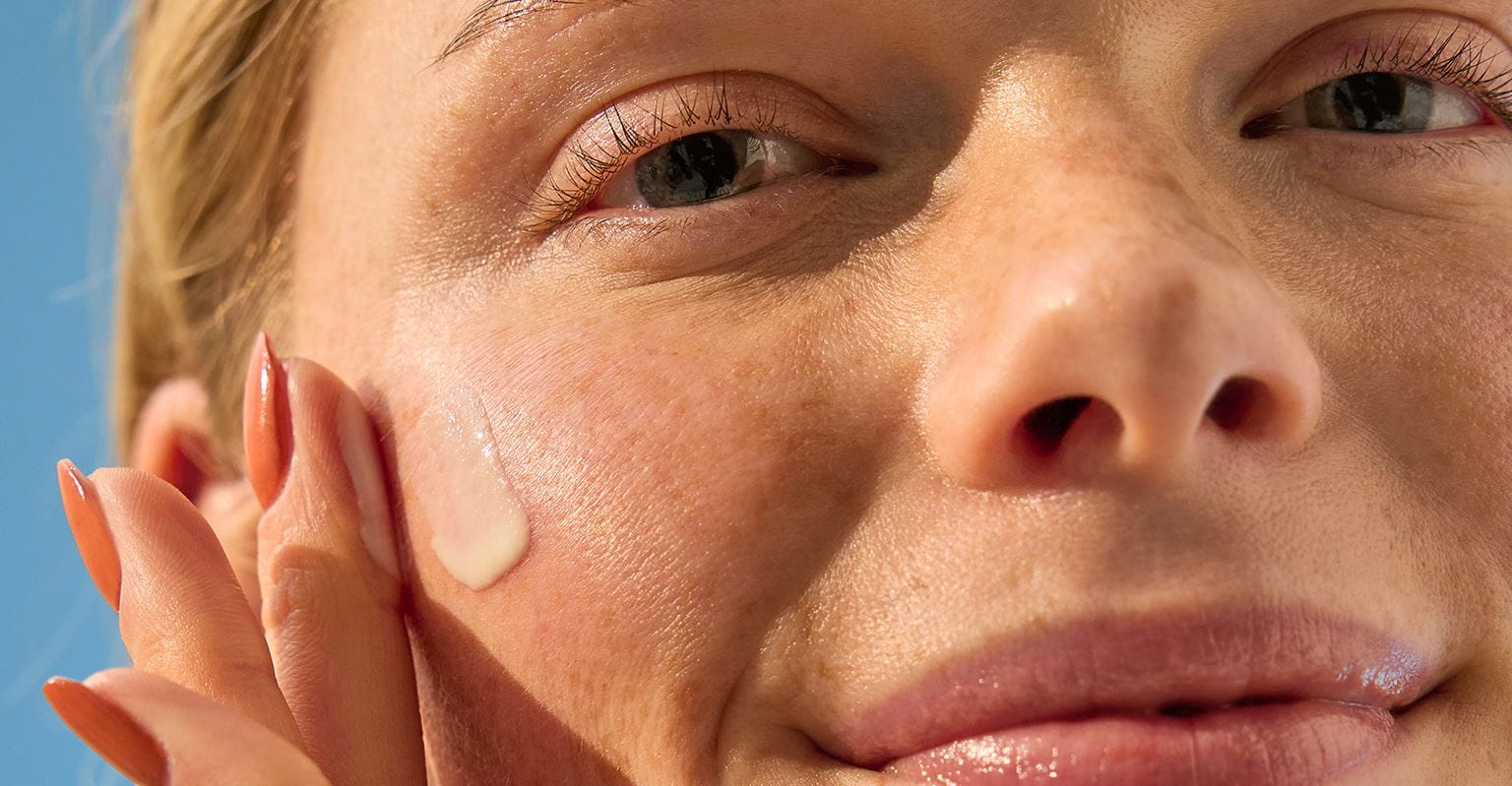 kvinde, der bruger øjencreme