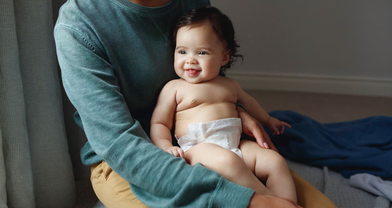 Baby auf dem Schoß sitzend