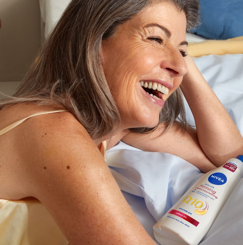 Woman using Nivea Body Milk Firming Q10