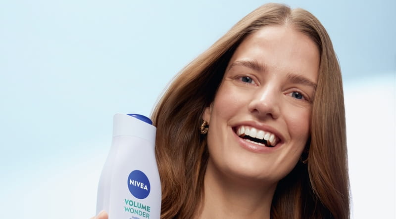 Junge Frau verwendet Nivea Volume Wonder Shampoo