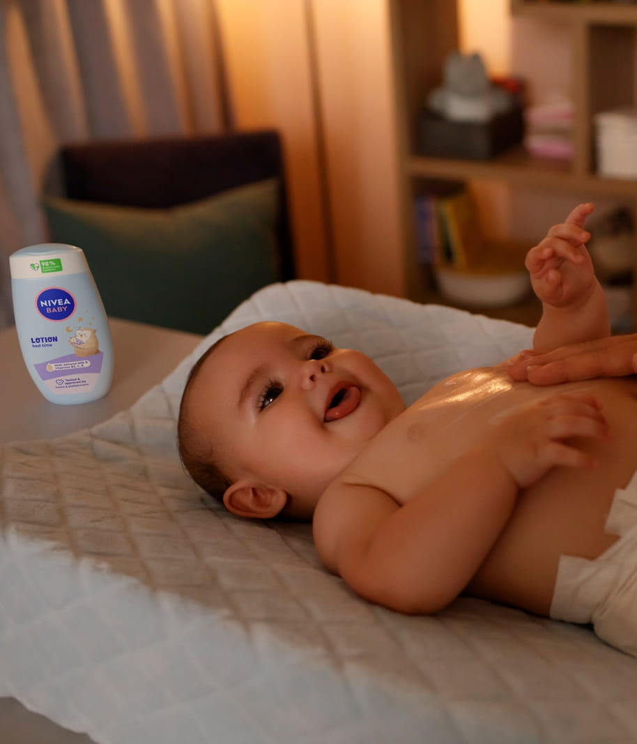 Eine Mutter trägt Nivea-Creme auf ihr Baby auf