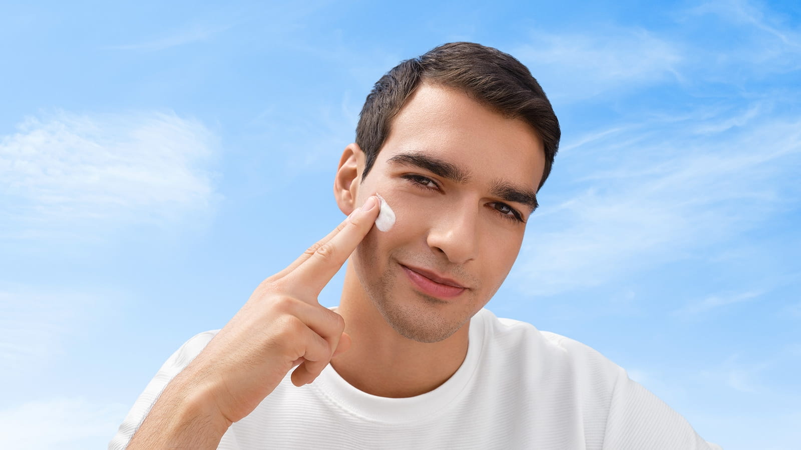 Homme avec de la crème solaire NIVEA sur le visage