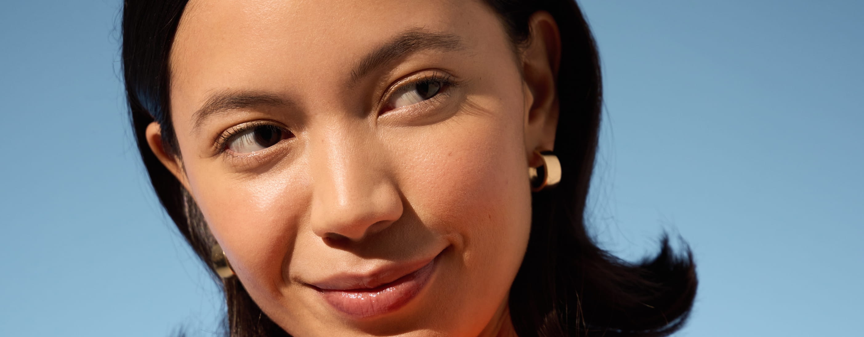 JUNGE FRAU, DIE IN DER SONNE STEHT