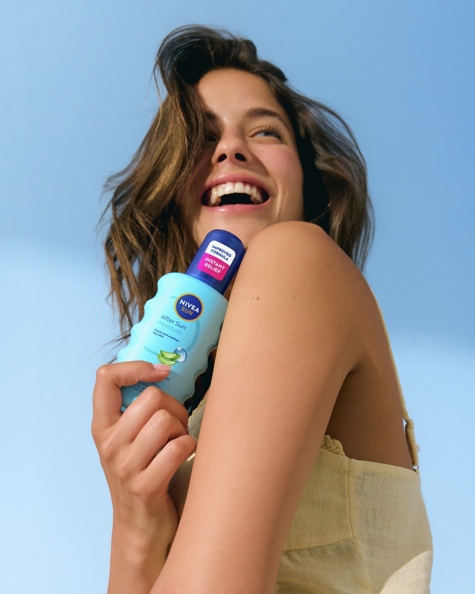 Ung kvinde bruger Nivea After Sun Moisture Spray