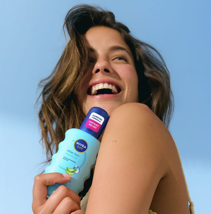 Giovane donna che utilizza lo spray idratante doposole Nivea