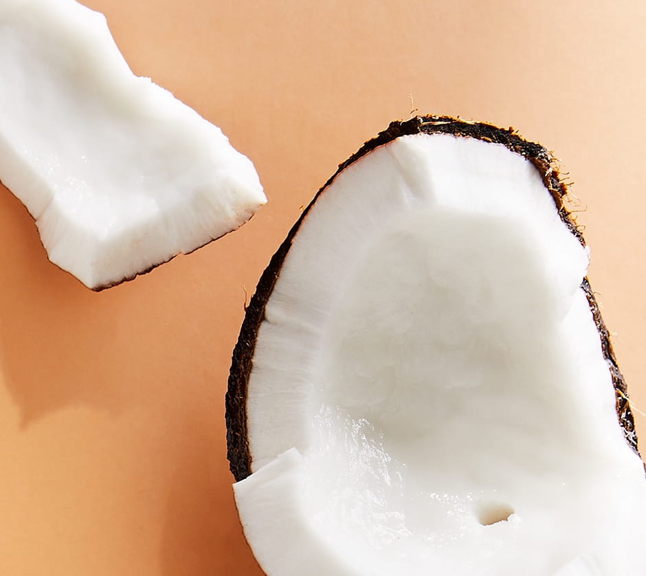 Närbild av bitar av en kokosnöt på orange bakgrund