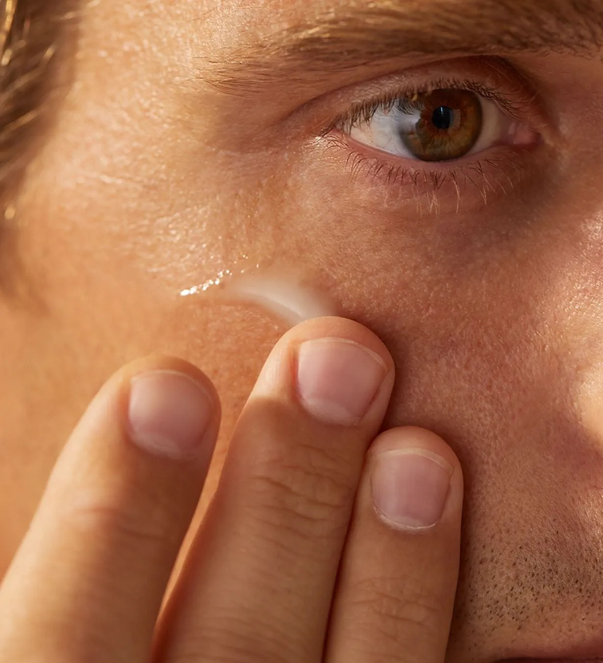 Homme appliquant la crème pour les yeux