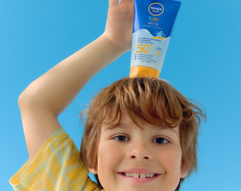 Kleiner Junge verwendet NIVEA Babies & Kids Sensitive Protect Spray SPF 50+