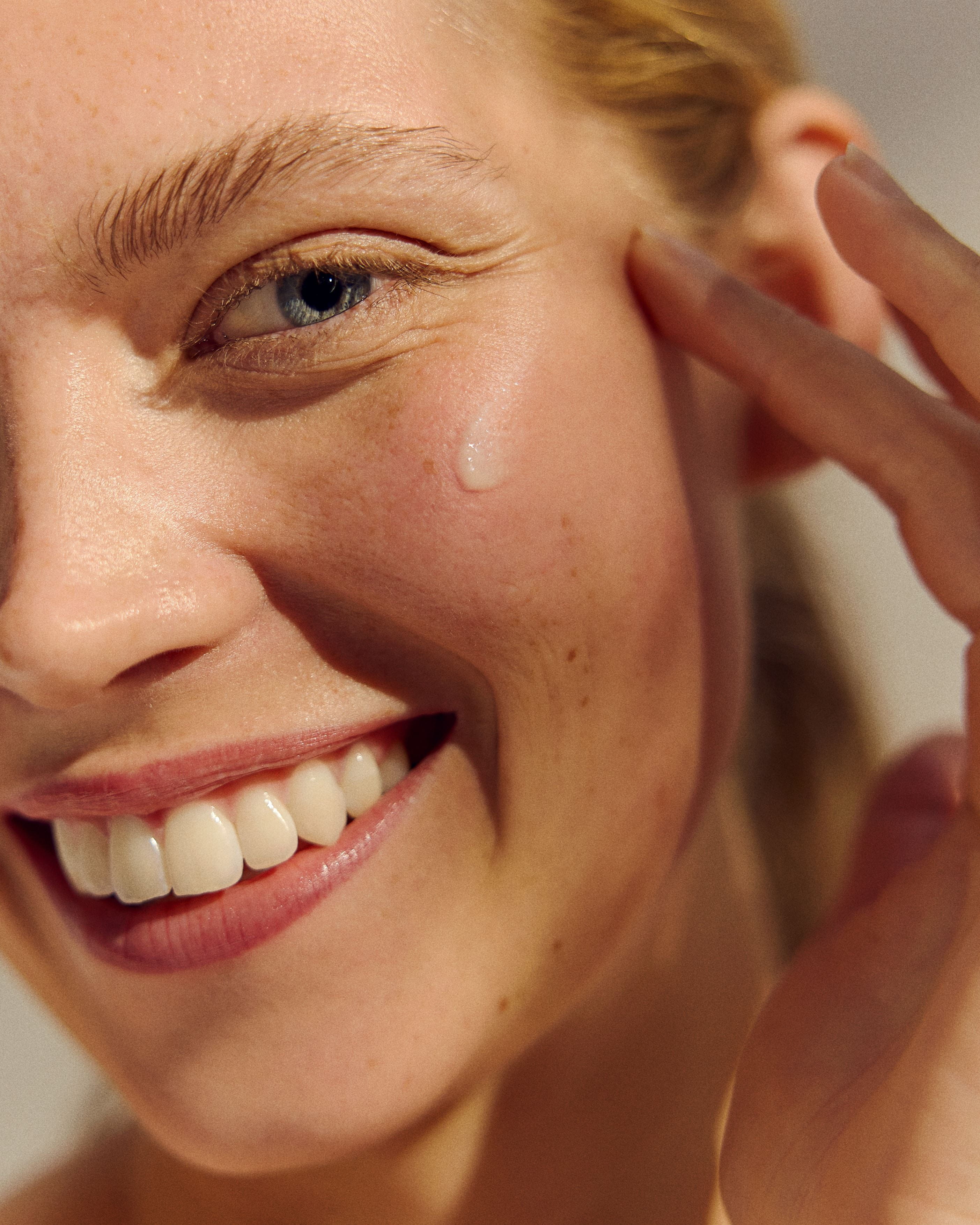 femme utilisant de la crème contour des yeux