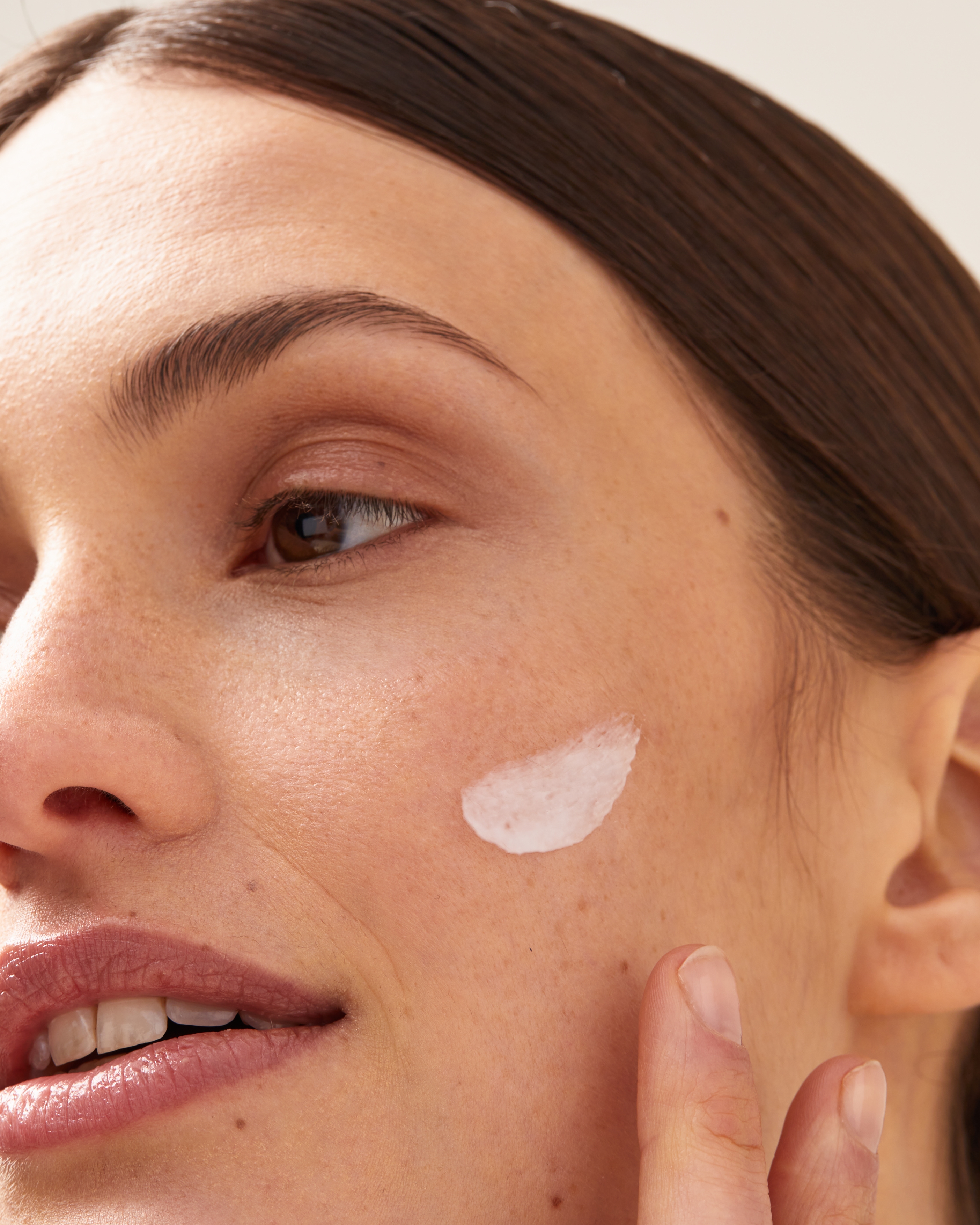 Persona aplicando crema en su rostro