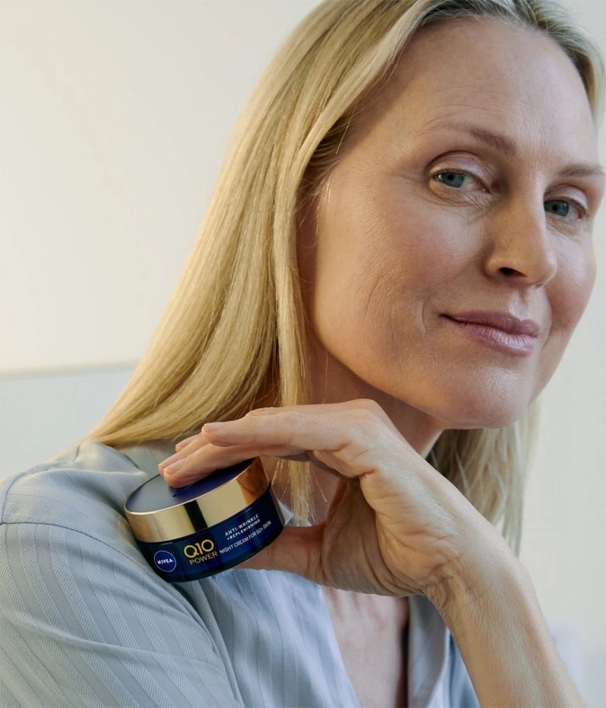 mulher idosa segurando um pote de creme nivea