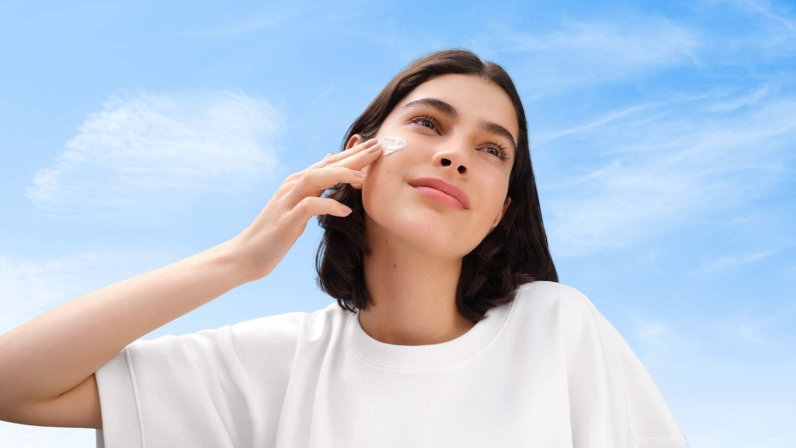 Femme avec de la crème solaire NIVEA sur le visage