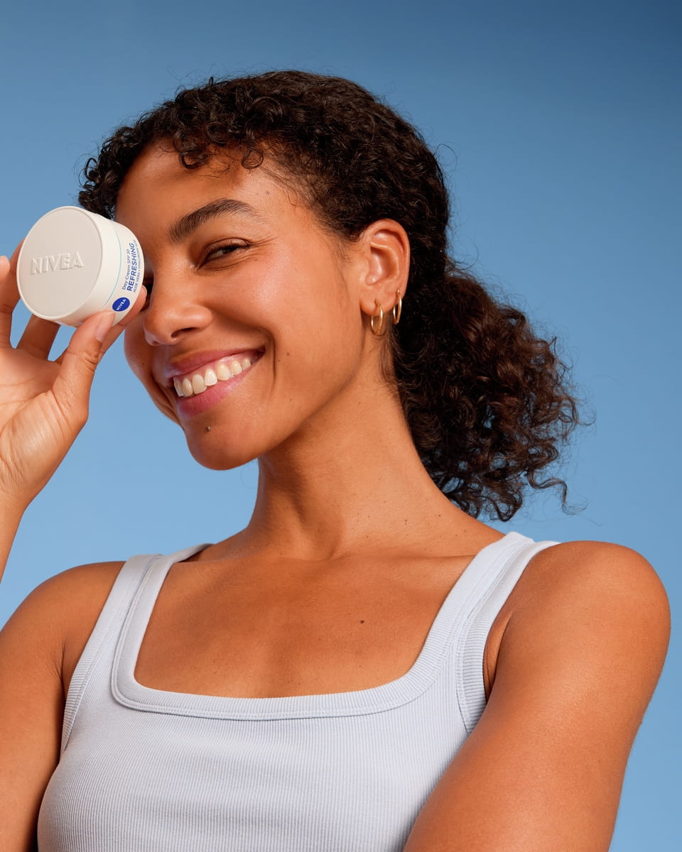 Joven utilizando la crema facial Nivea.