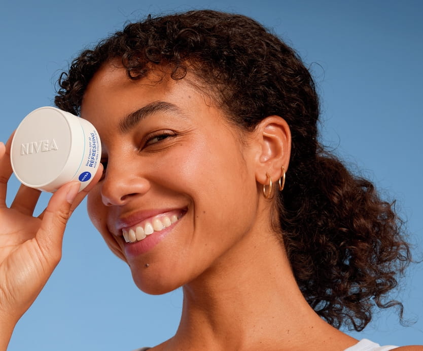 Young woman using Nivea face cream