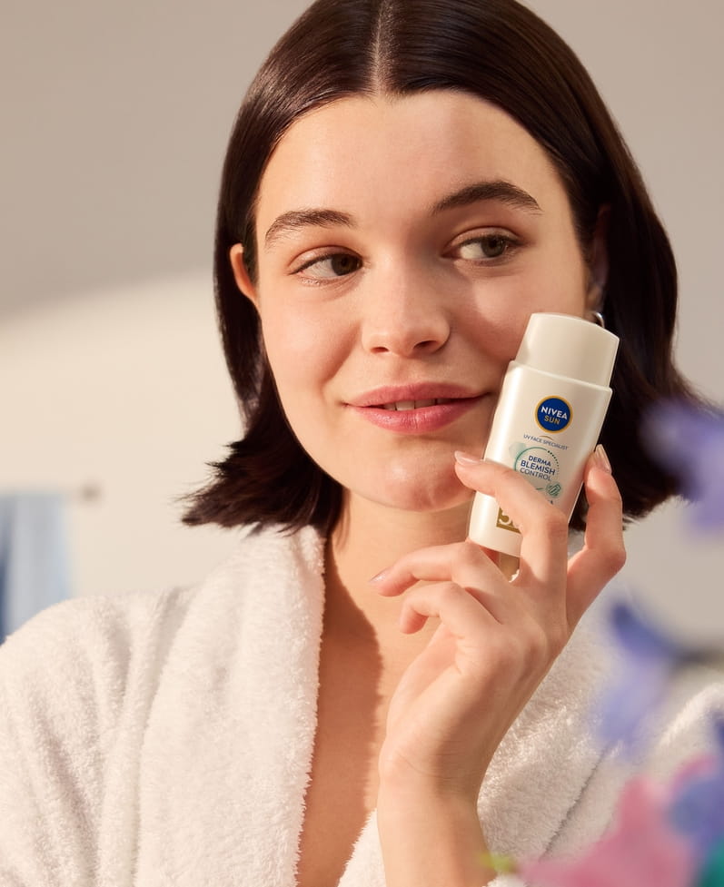 Jeune femme utilisant NIVEA Sun UV Face Specialist Derma Skin Clear