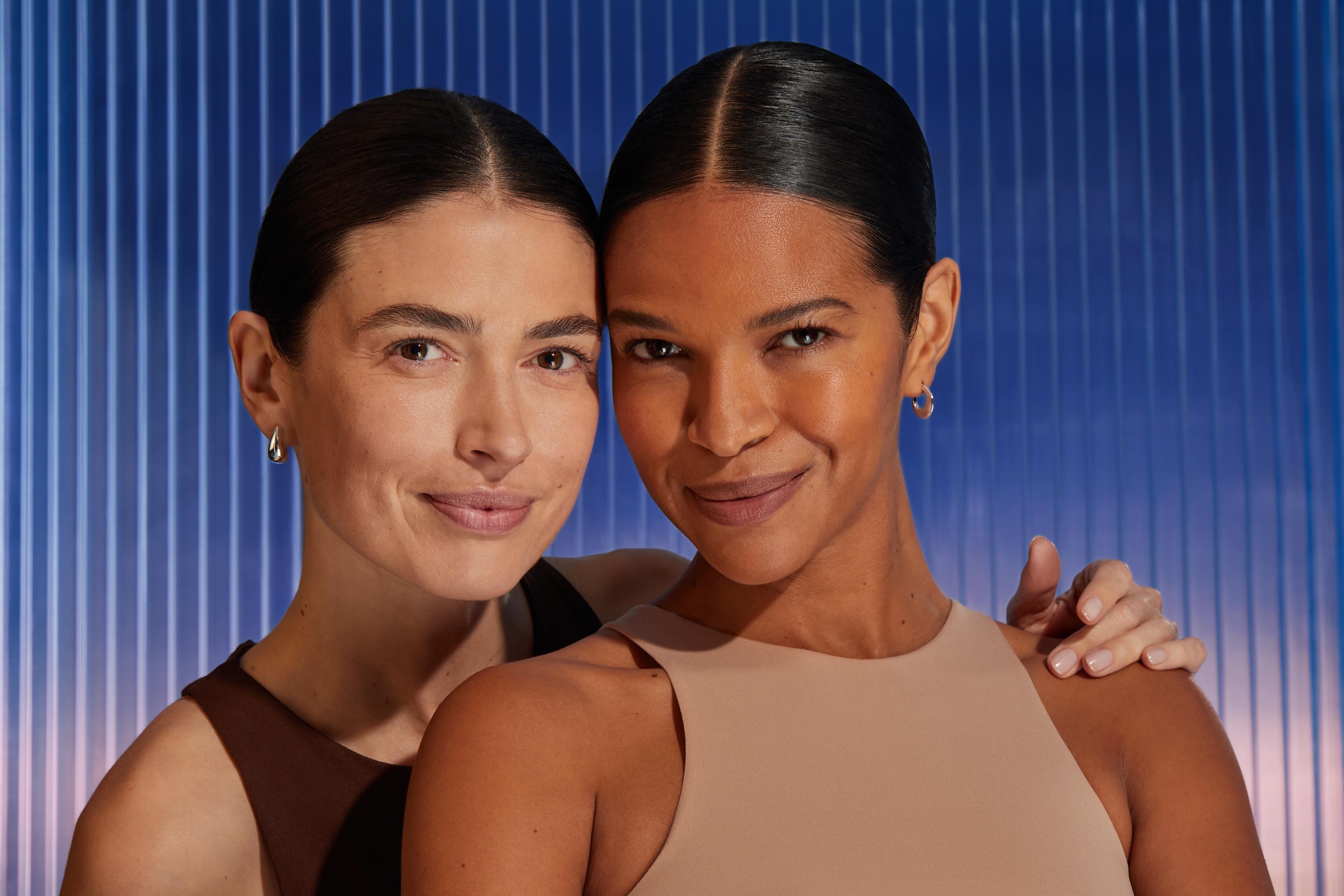 Två kvinnor ler in i kameran