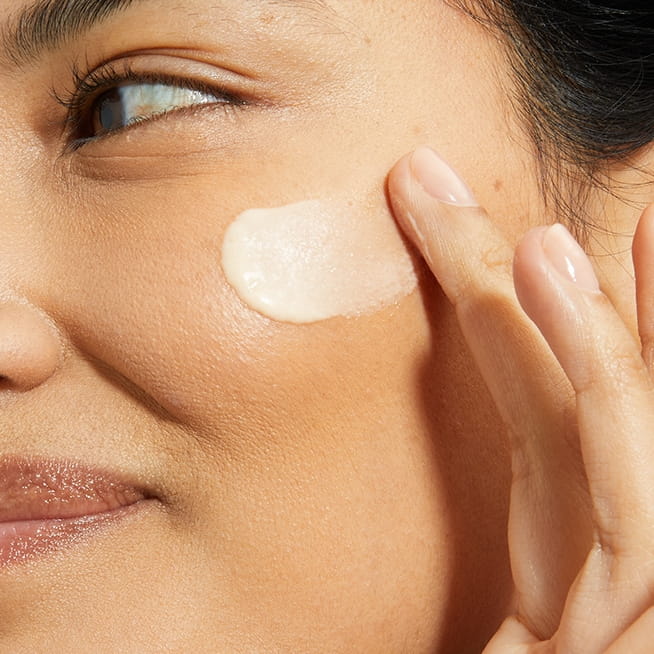 woman using day cream as step 2 in face routine