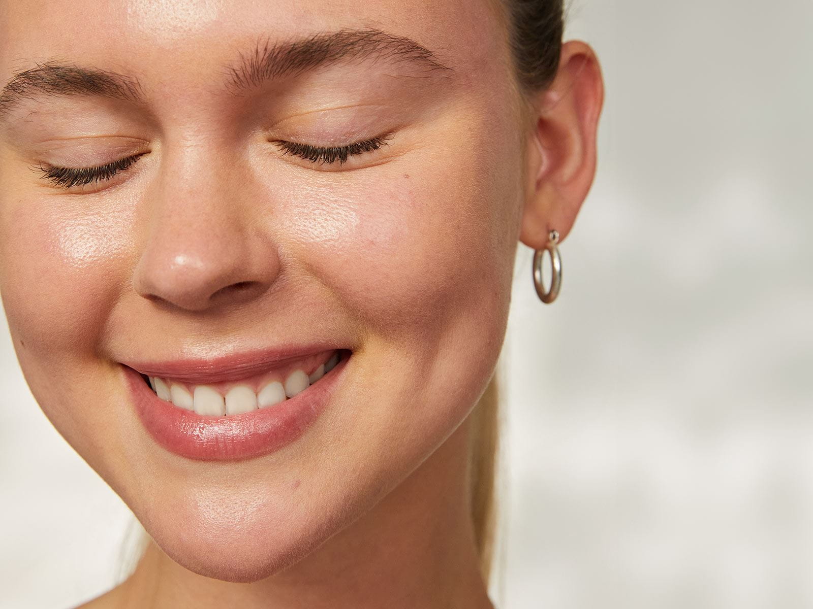 View of a person smiling with their eyes closed.