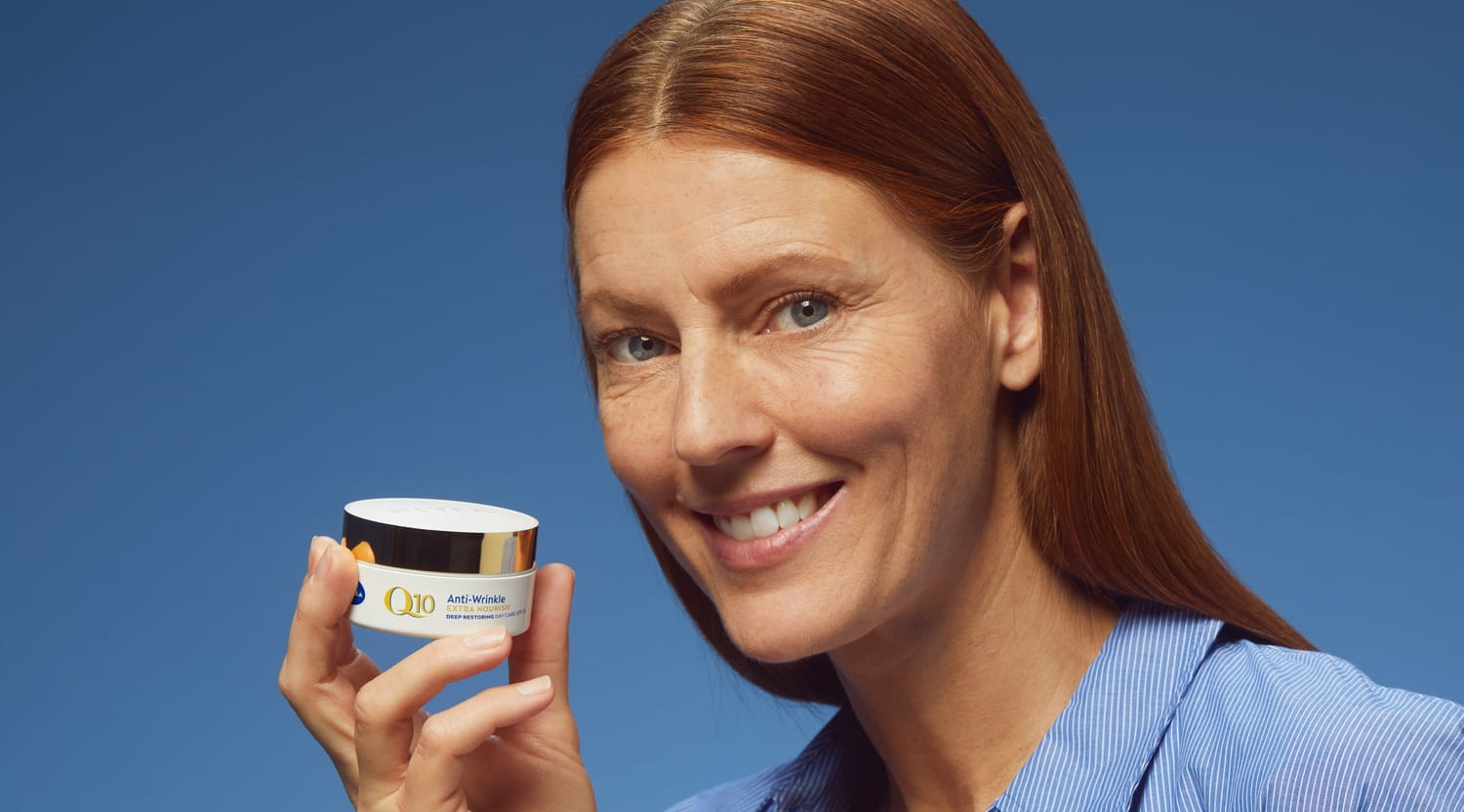 Donna che utilizza la crema viso antirughe Nivea Q10