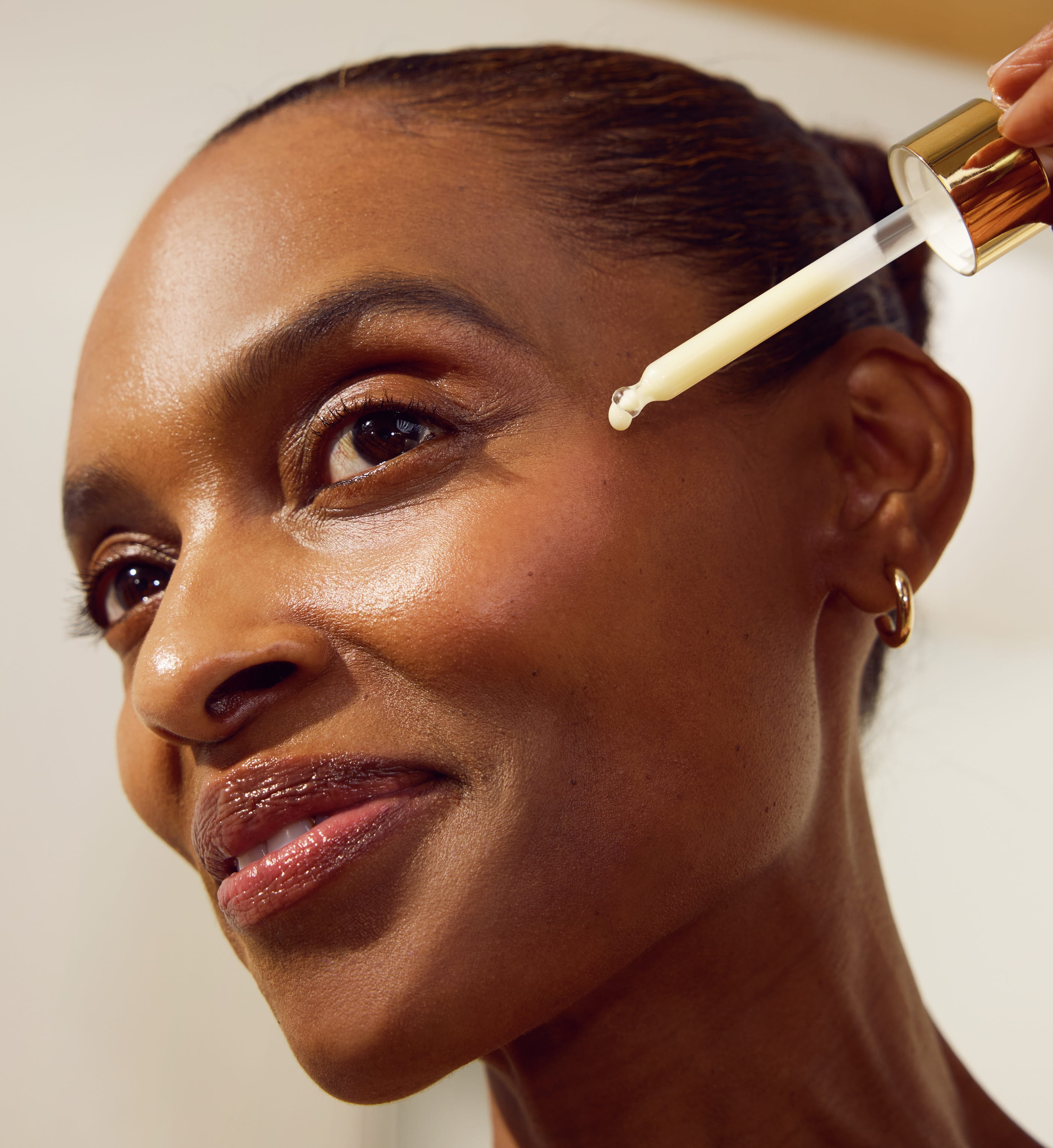 person applicerar serum till ansiktet