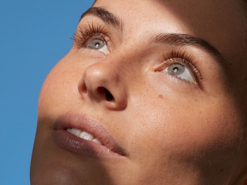 femme tenant une crème pour le visage Nivea Sun Spot Control