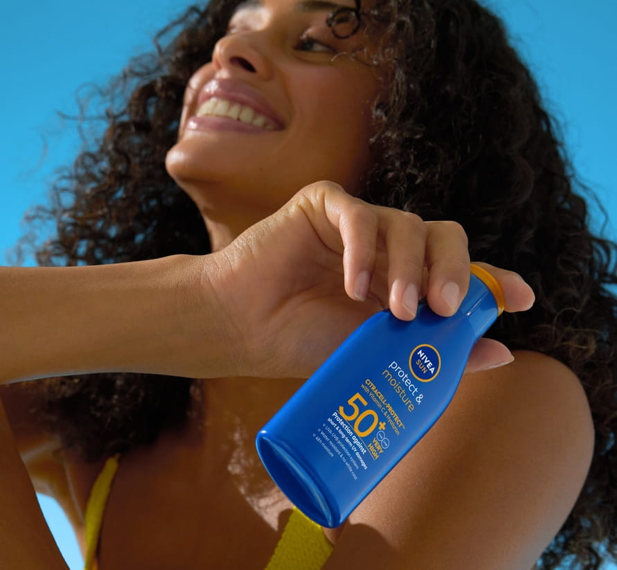 Giovane donna che utilizza il balsamo labbra NIVEA Hyaluron Moisture Plus