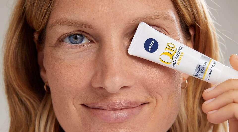 Femme utilisant la CRÈME POUR LES YEUX ANTI-RIDES POWER EXTRA FIRMING Q10 de NIVEA