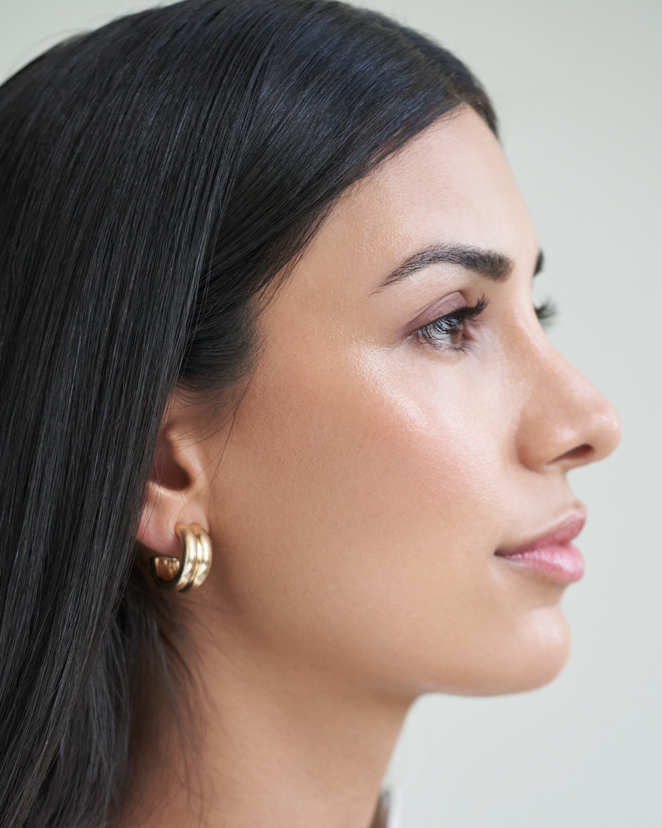 donna con in mano una crema per il viso Nivea Q10