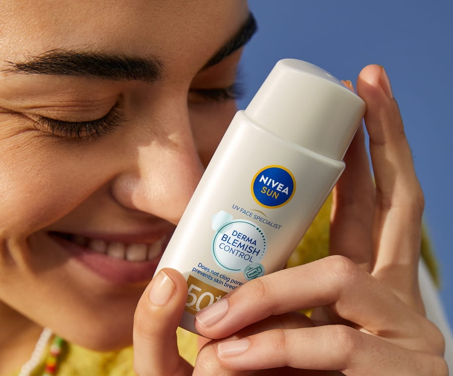 Young woman using NIVEA Sun UV Face Specialist Derma Skin Clear SPF 50+ 40ml