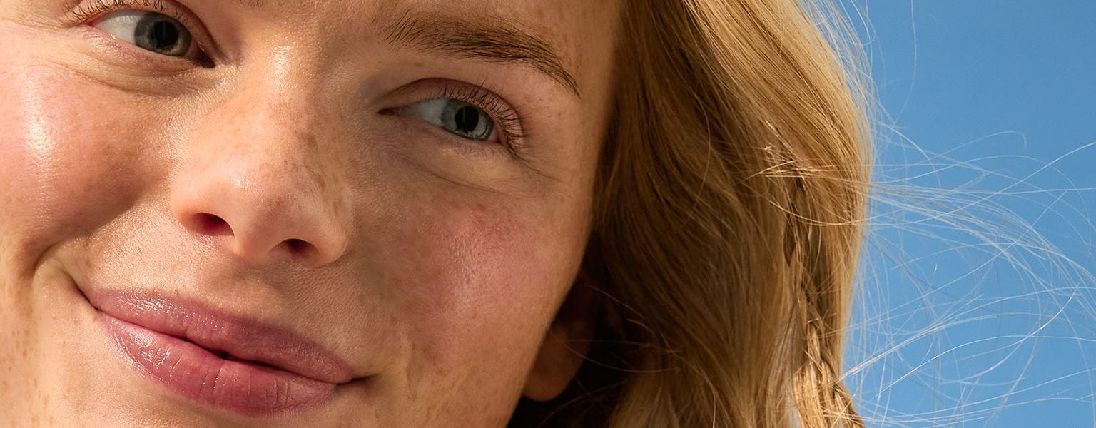 Frau mit ihrem Gesicht in der Sonne