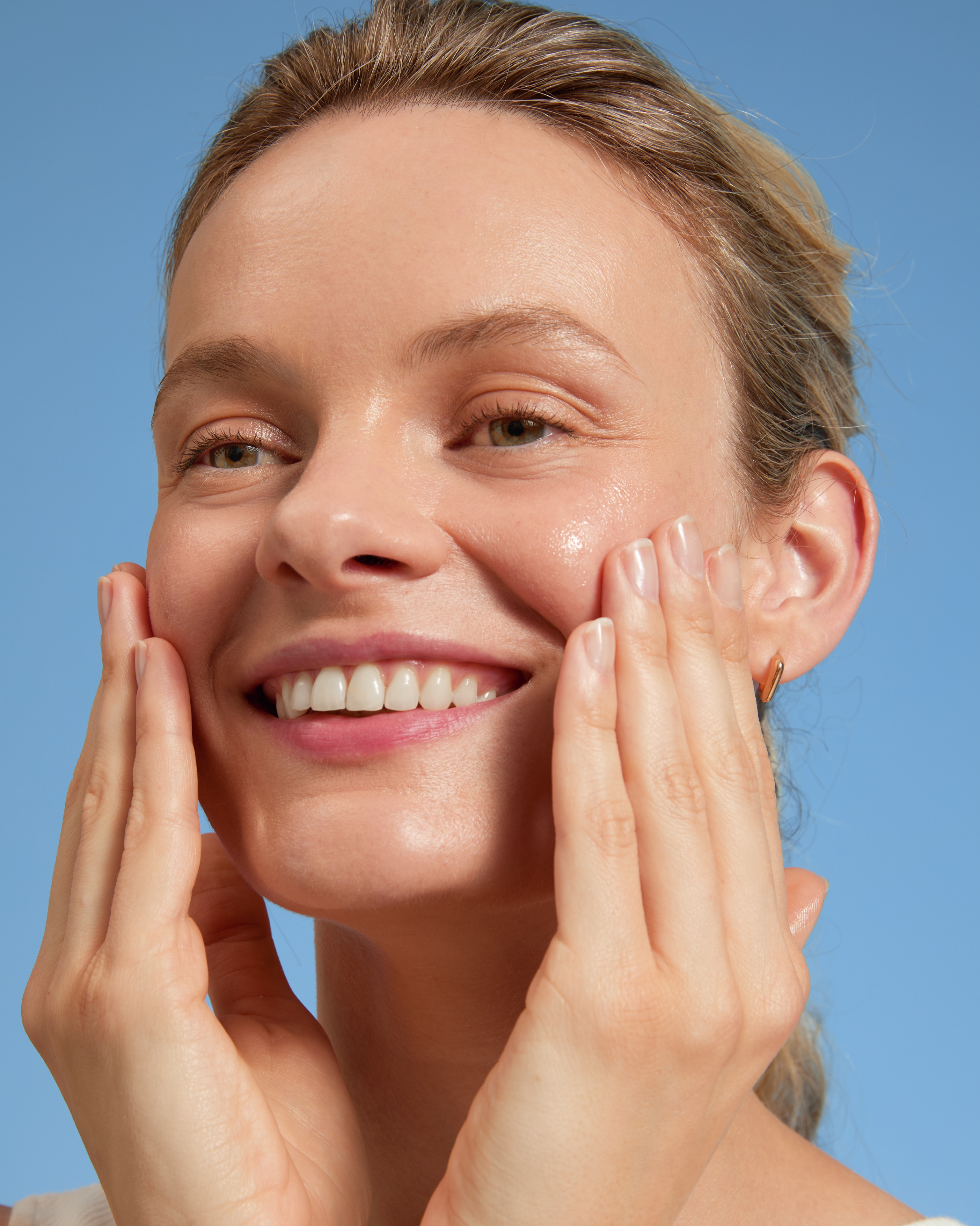 woman avoiding dead skin cells on face in shower