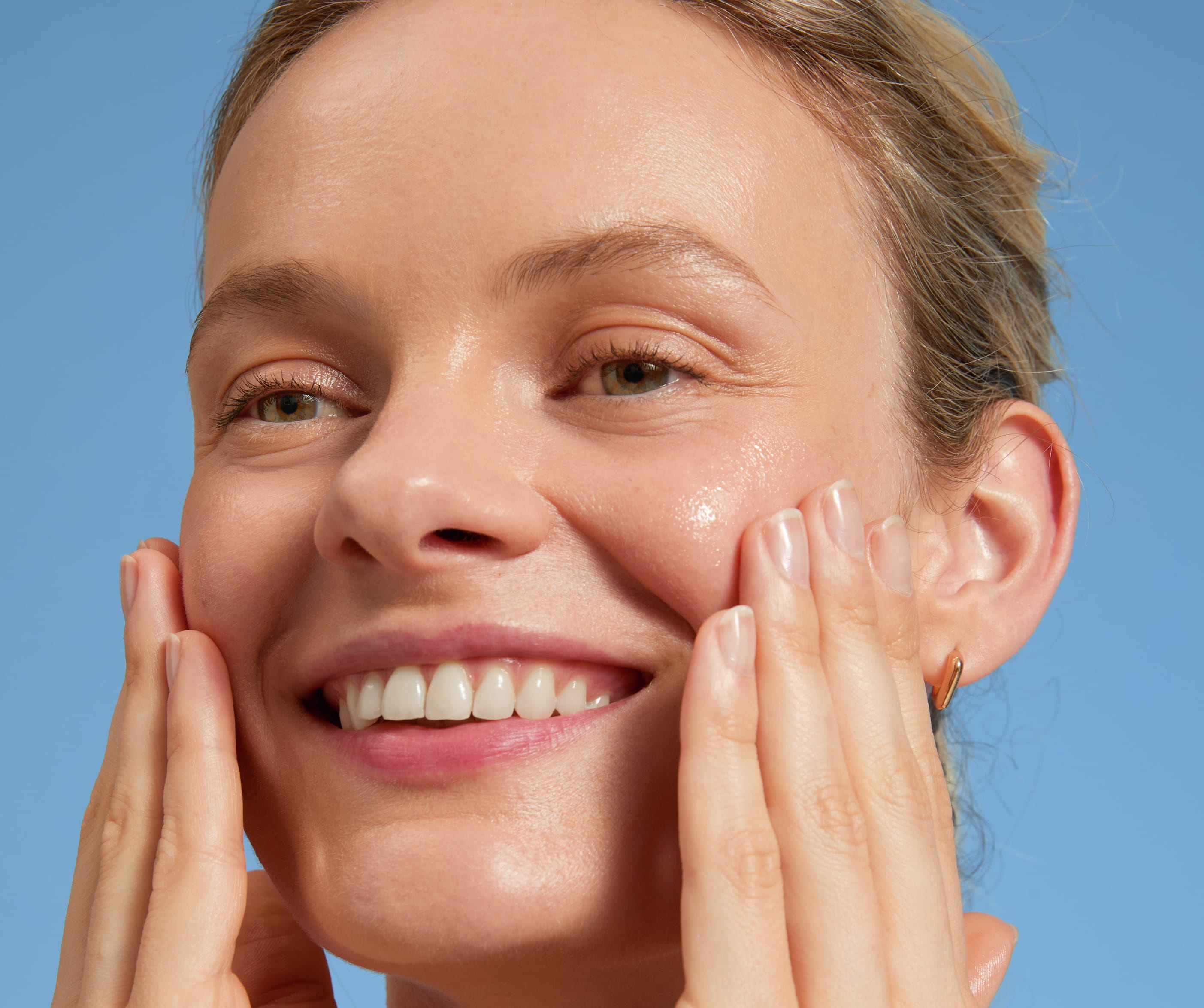 woman avoiding dead skin cells on face in shower