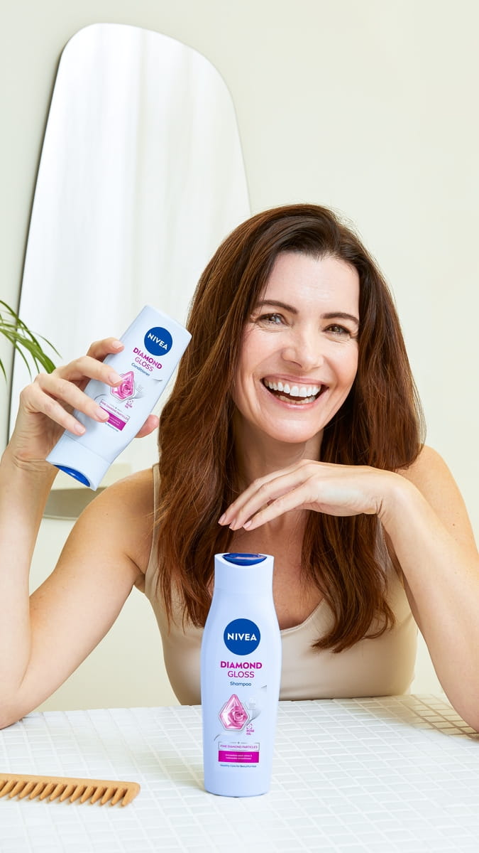 Junge Frau mit dunklem Haar, die Diamond Gloss Brillant Spülung verwendet