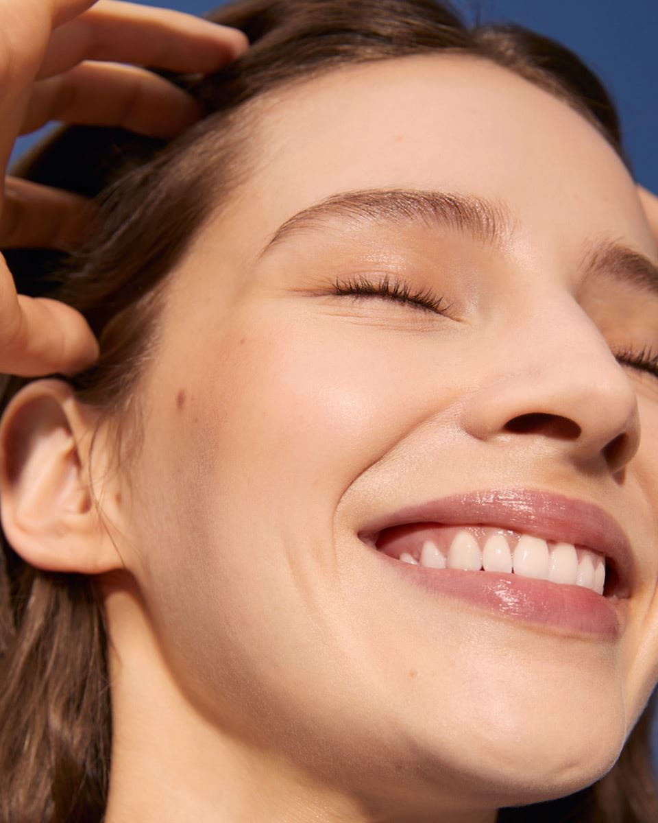 View of a person smiling with their eyes closed.